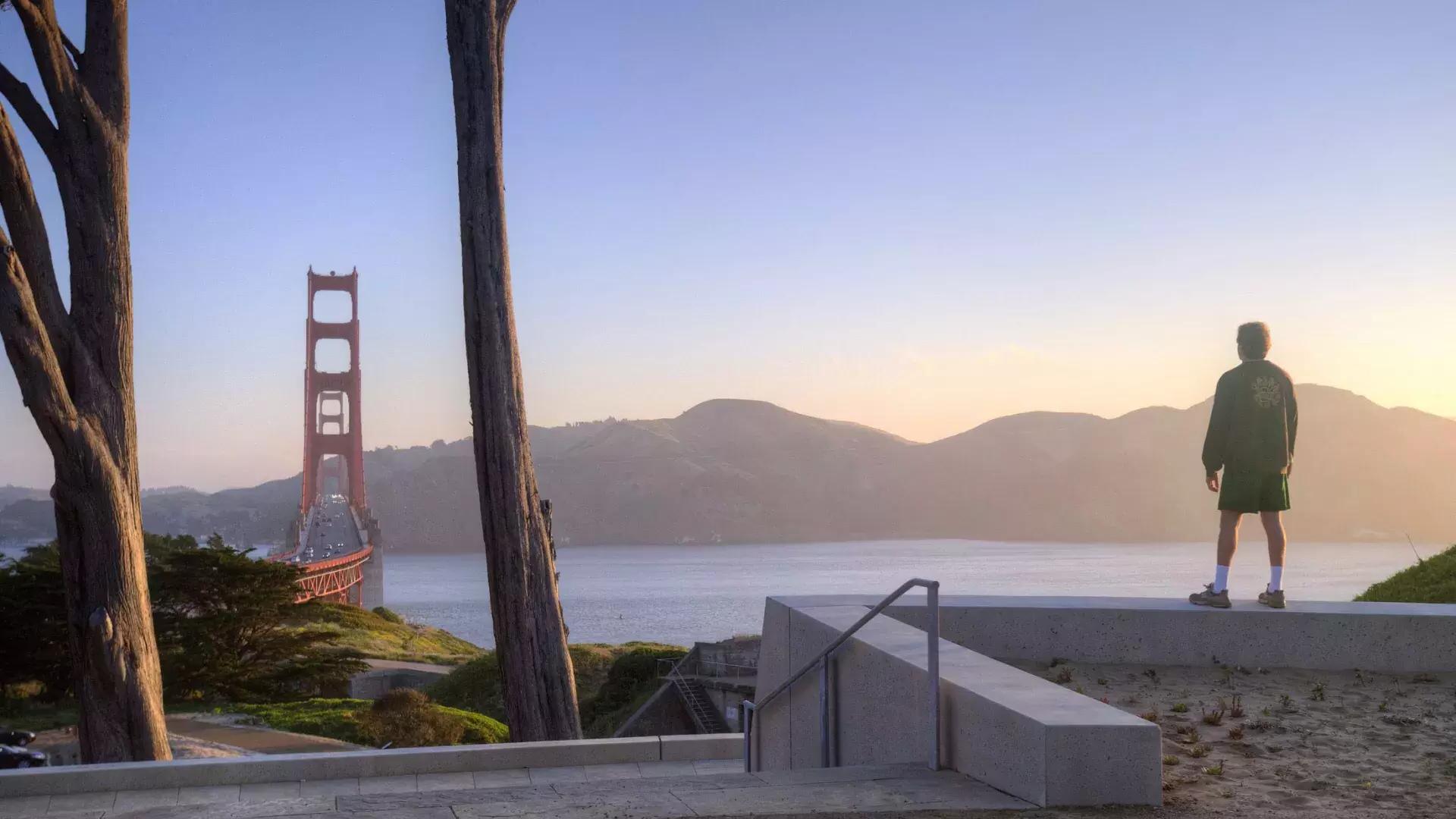 Um homem observa a ponte Golden Gate 和 montanhas ao fundo.