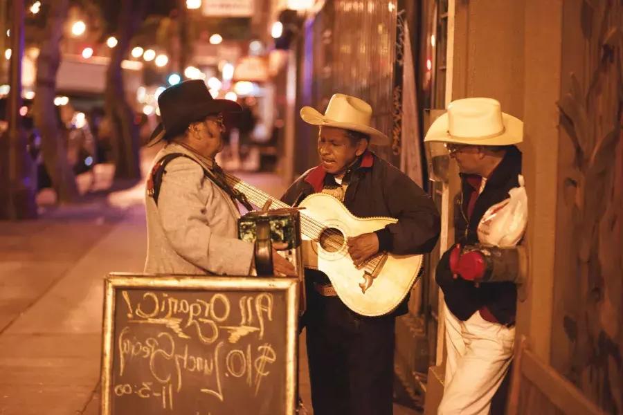三位墨西哥音乐家在贝博体彩app教会区的街道上表演.