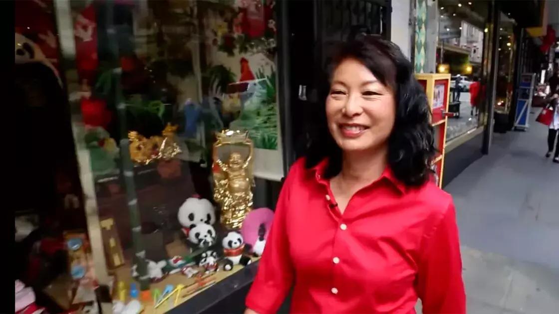Linda Lee walks through the streets of Chinatown wearing a red shirt. 加州贝博体彩app.